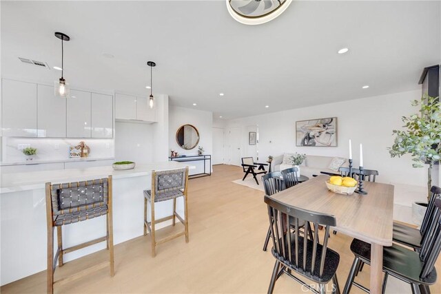 dining room with light wood-style floors, recessed lighting, and visible vents