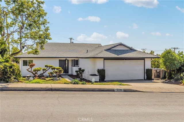 single story home with a garage, roof with shingles, concrete driveway, and stucco siding