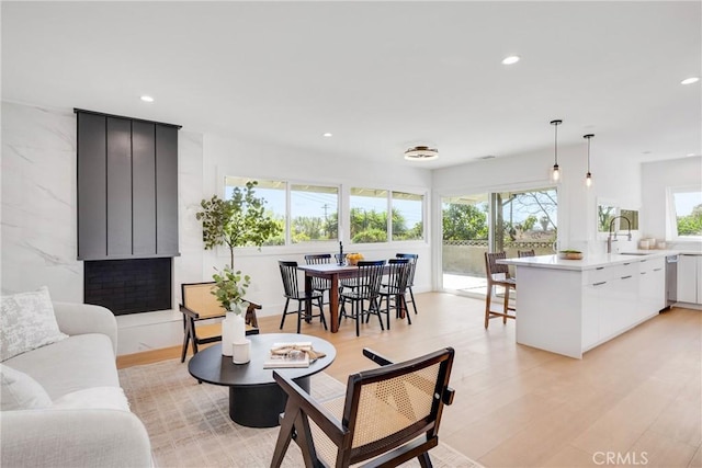 living area with light wood-type flooring, a healthy amount of sunlight, and recessed lighting