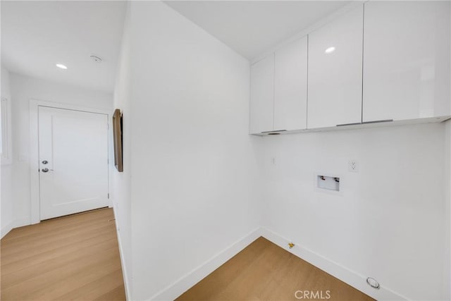 laundry room with cabinet space, baseboards, hookup for a gas dryer, light wood-type flooring, and washer hookup