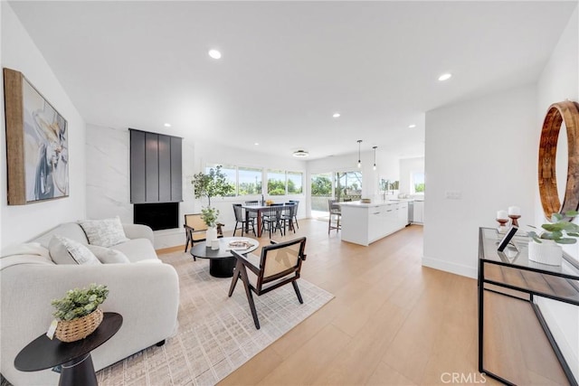 living room with light wood-style floors, baseboards, and recessed lighting