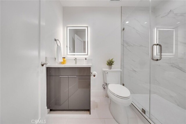 full bathroom featuring toilet, baseboards, a marble finish shower, and vanity