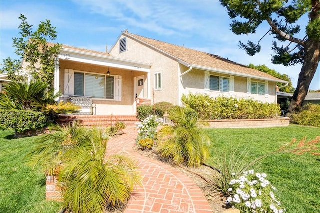 view of front of home with a front yard and stucco siding