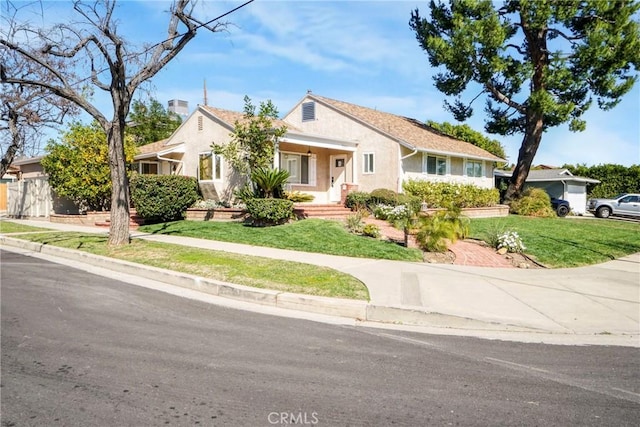 view of front of home featuring stucco siding and a front yard