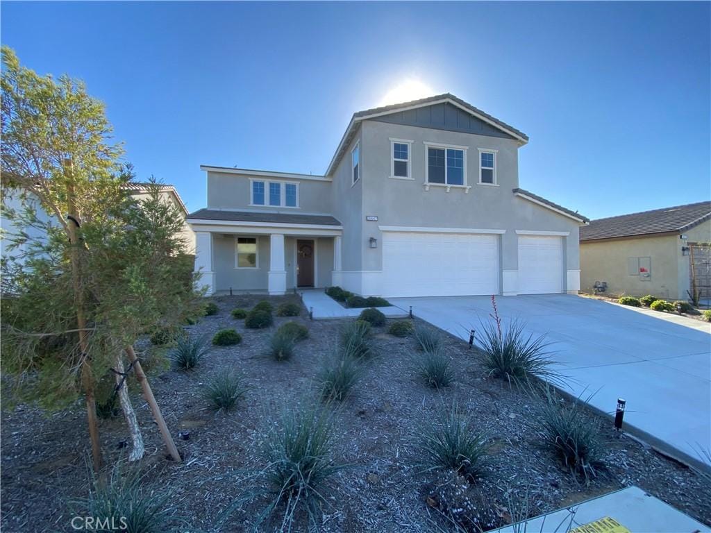 view of front of house with driveway, a garage, and stucco siding