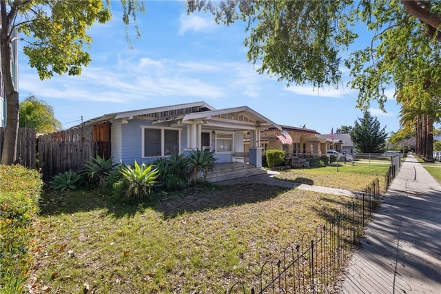 view of front of home featuring a porch, a front yard, and fence