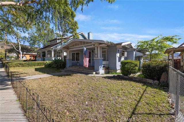 view of front of property featuring a porch, fence, a front lawn, and cooling unit