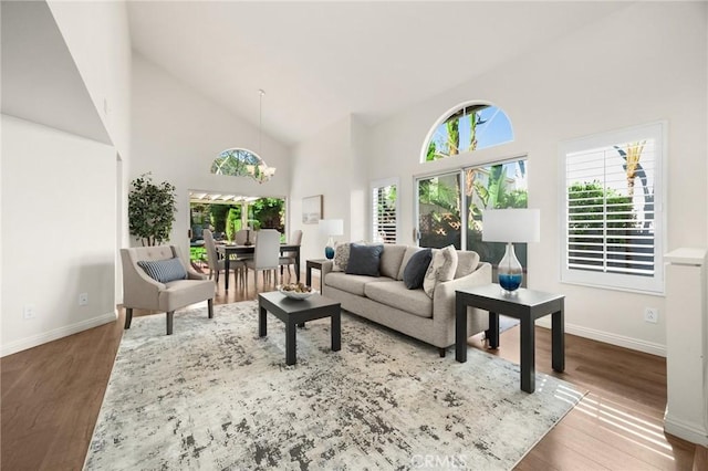 living room with high vaulted ceiling, wood finished floors, and baseboards