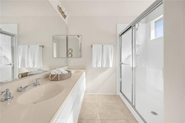 full bathroom with double vanity, a stall shower, tile patterned flooring, and a sink