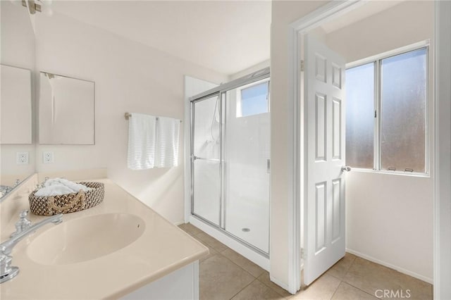 bathroom featuring double vanity, tile patterned floors, a sink, and a shower stall