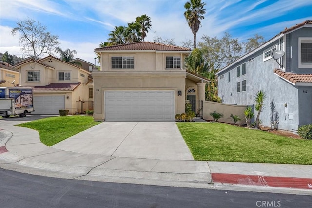 mediterranean / spanish home with an attached garage, a tile roof, a front yard, and stucco siding