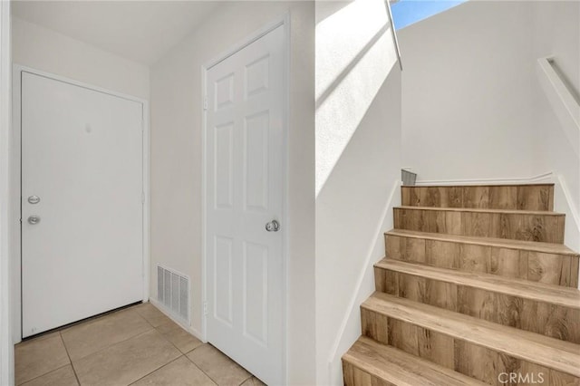 stairs with visible vents and tile patterned floors