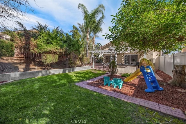 view of yard featuring a playground, fence, and a pergola