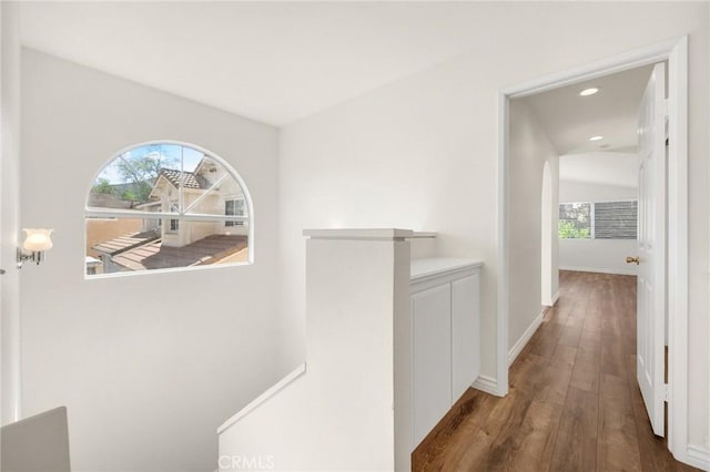 hall featuring baseboards, wood finished floors, an upstairs landing, and recessed lighting