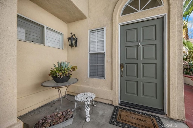 property entrance with stucco siding