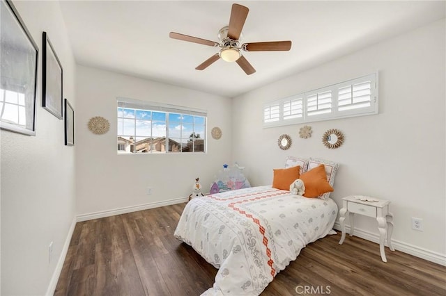 bedroom featuring dark wood-style floors, multiple windows, baseboards, and a ceiling fan