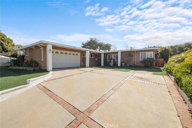 single story home with an attached garage, stucco siding, driveway, and a front yard