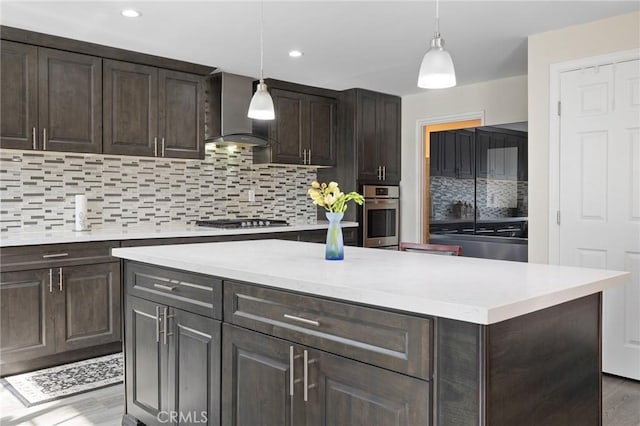 kitchen with decorative backsplash, stainless steel oven, wall chimney range hood, gas cooktop, and dark brown cabinets