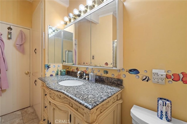 bathroom with toilet, tile patterned flooring, and vanity