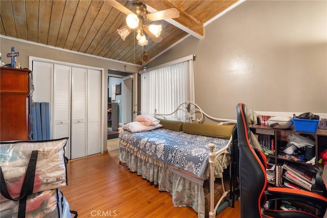 bedroom featuring lofted ceiling with beams, wooden ceiling, wood finished floors, and a ceiling fan