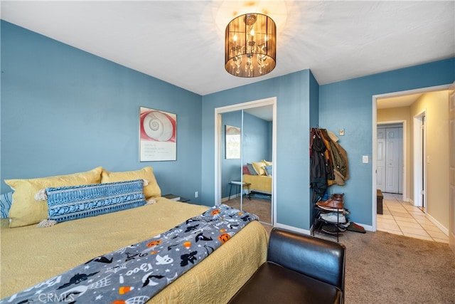 tiled bedroom with carpet floors, baseboards, a chandelier, and a closet