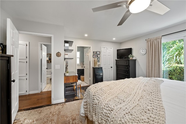 bedroom with ensuite bathroom, ceiling fan, recessed lighting, wood finished floors, and baseboards