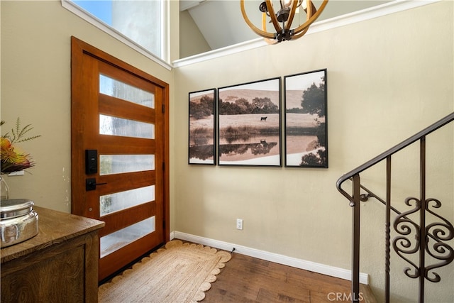 foyer with baseboards, stairway, a chandelier, and wood finished floors