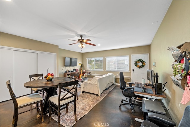 dining area with ceiling fan and concrete floors