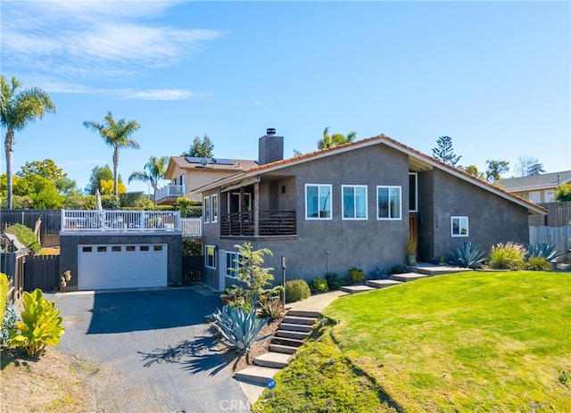 view of front of home with aphalt driveway, fence, stucco siding, a front lawn, and a chimney