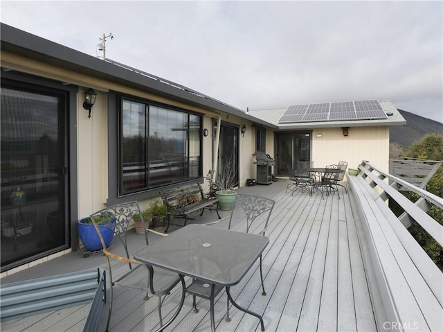 deck featuring outdoor dining area and a grill