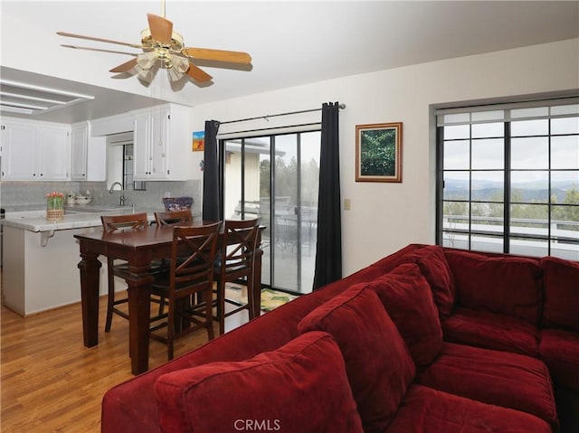 living room with a healthy amount of sunlight, light wood-style floors, and ceiling fan