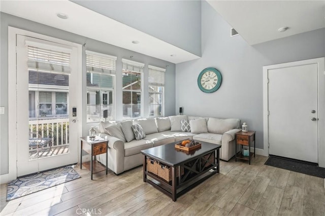 living area featuring light wood finished floors and visible vents