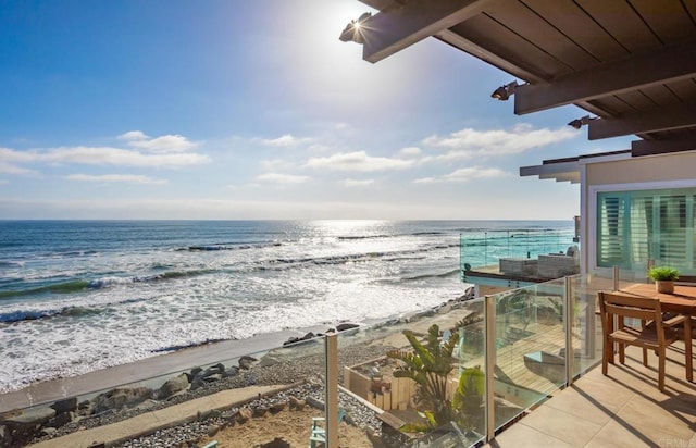 balcony featuring a water view and a view of the beach