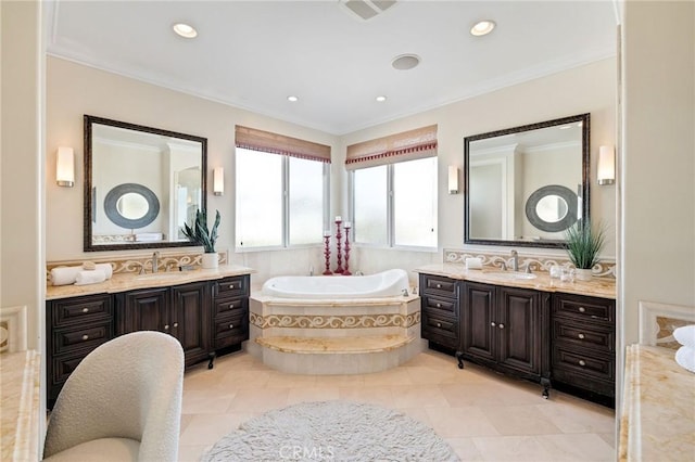 full bath with a garden tub, ornamental molding, and two vanities