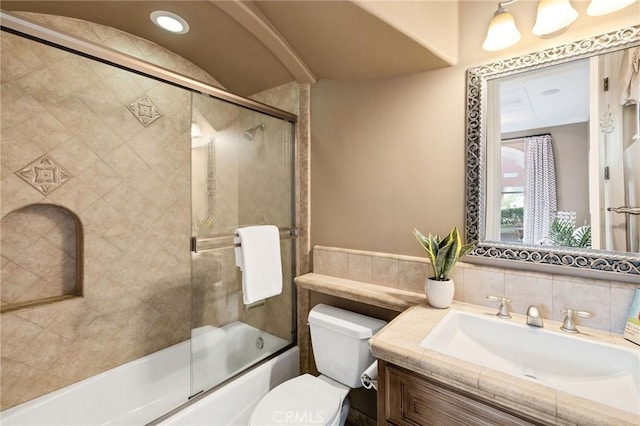 full bath with bath / shower combo with glass door, vanity, and toilet