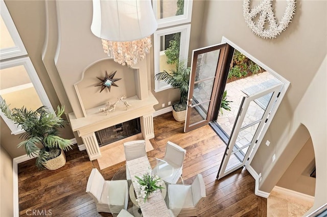 foyer with a towering ceiling, wood-type flooring, and baseboards