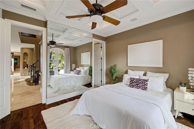 bedroom with ceiling fan, hardwood / wood-style flooring, coffered ceiling, visible vents, and crown molding