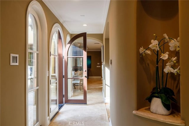 corridor featuring arched walkways, ornamental molding, recessed lighting, and baseboards