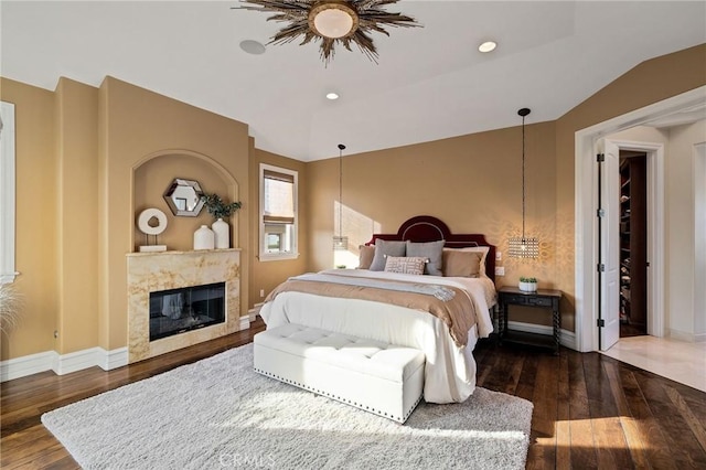 bedroom featuring vaulted ceiling, hardwood / wood-style floors, and baseboards