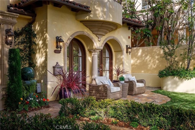 doorway to property featuring a patio area and stucco siding