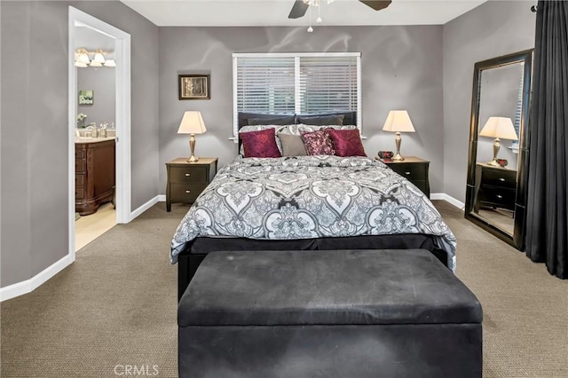 bedroom with ensuite bathroom, carpet flooring, and baseboards