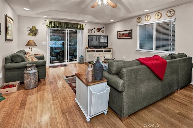 living room with a ceiling fan, recessed lighting, a tray ceiling, and wood finished floors