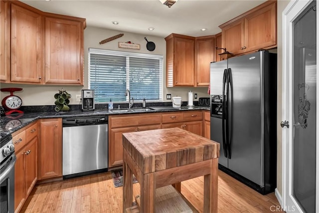 kitchen with stainless steel appliances, light wood-type flooring, a sink, and recessed lighting