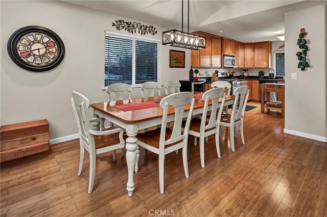 dining area featuring light wood-style floors and baseboards