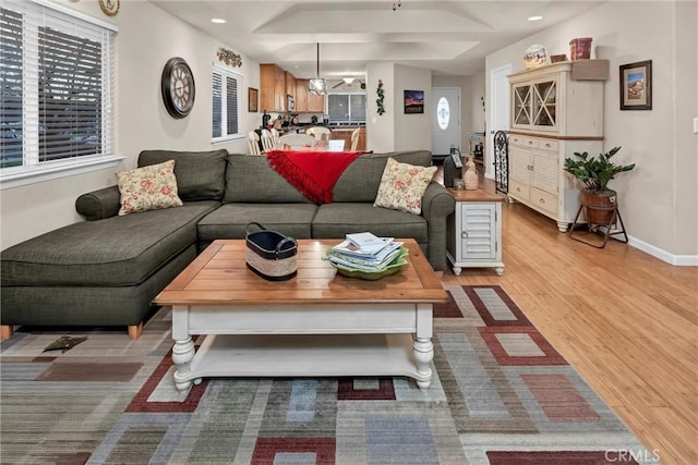 living room featuring light wood finished floors, plenty of natural light, baseboards, and recessed lighting