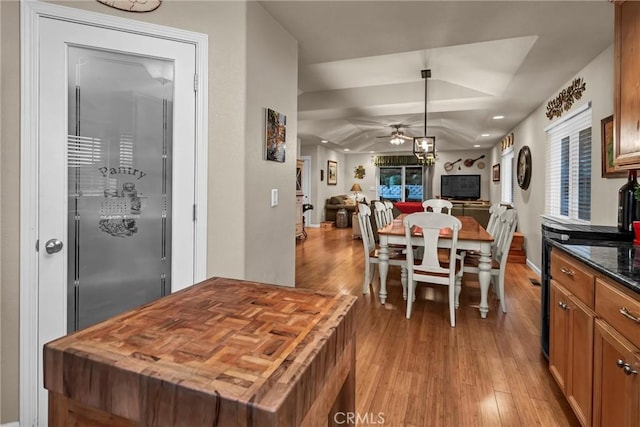 dining room with lofted ceiling, light wood-type flooring, and a ceiling fan