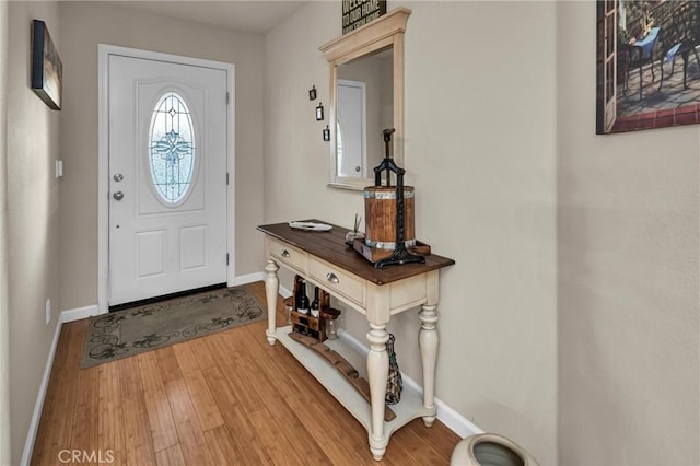 foyer entrance featuring baseboards and wood finished floors