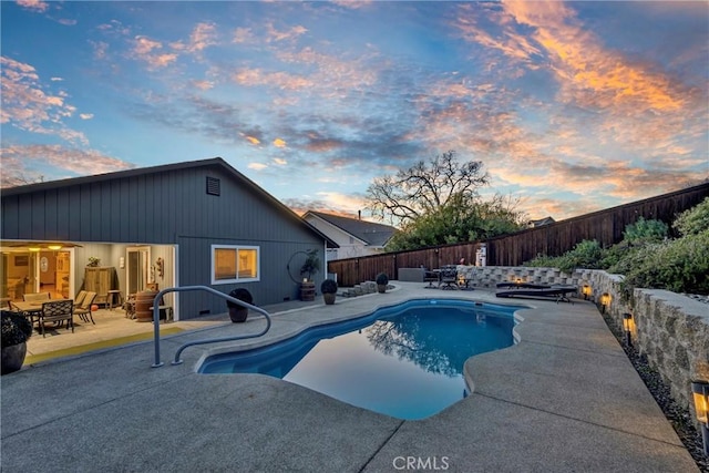 pool at dusk with a fenced in pool, a fenced backyard, and a patio