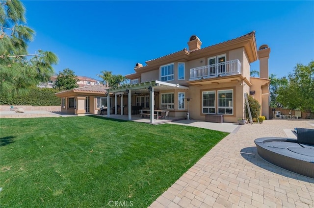 back of house featuring a patio area, a chimney, a lawn, and a pergola