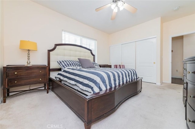 bedroom featuring light carpet, ceiling fan, and a closet